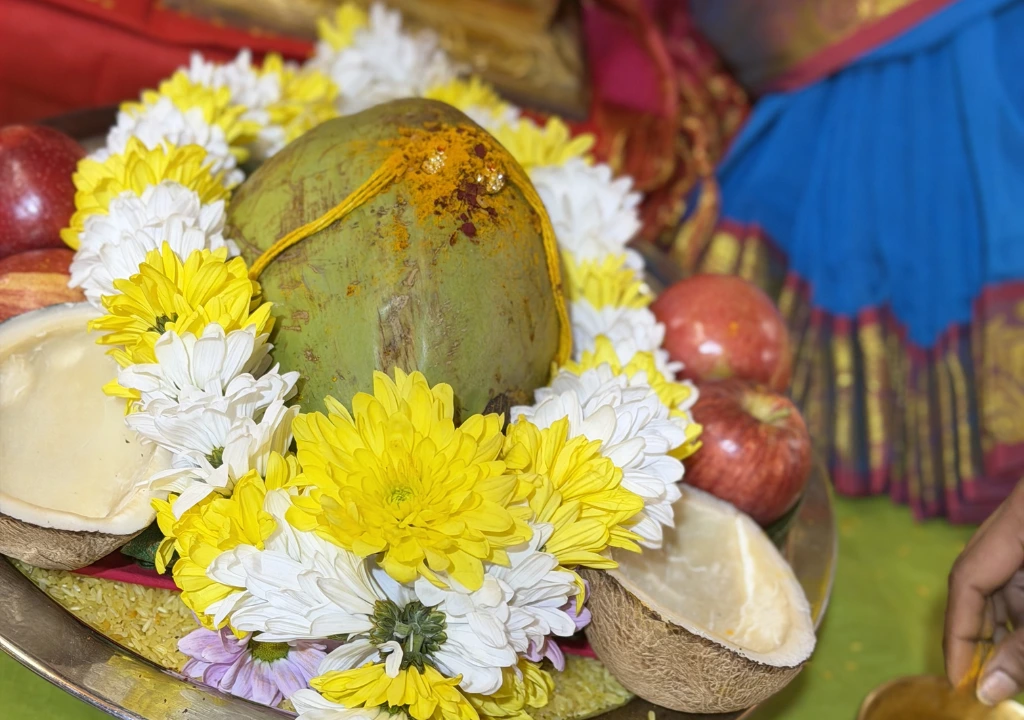 Temple prasadam plate with coconut, flowers, and fruits arranged for offering